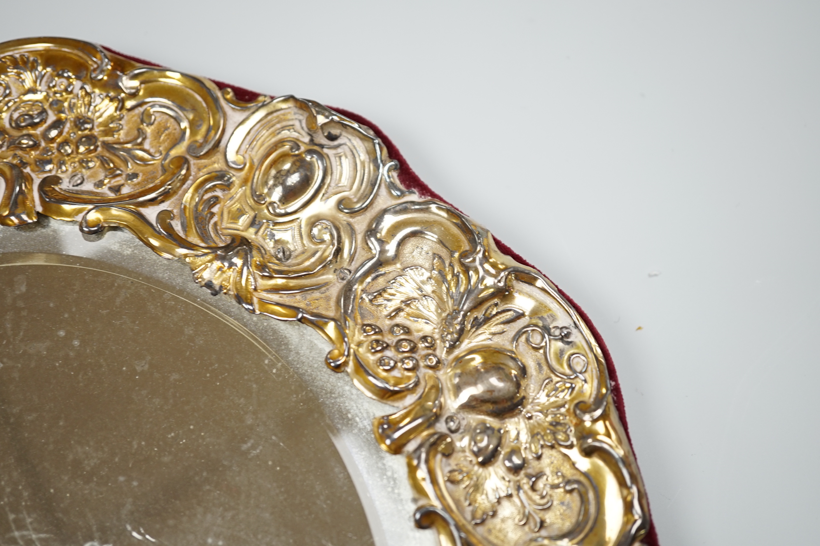 An Edwardian silver mounted circular easel mirror, Walker & Hall, 26.5cm, an Art Nouveau silver trinket box, William Hutton & Sons, London , 1904 and a silver milk jug.